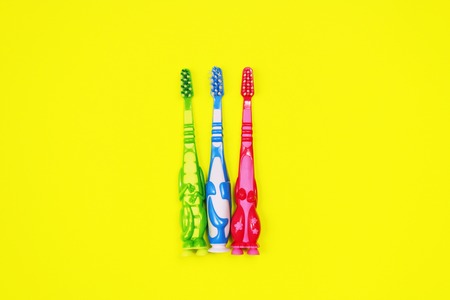 Baby toothbrushes on yellow backgroundの写真素材