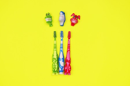 Baby toothbrushes on yellow backgroundの写真素材