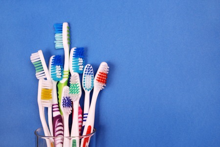 Toothbrushes in glass on blue backgroundの写真素材