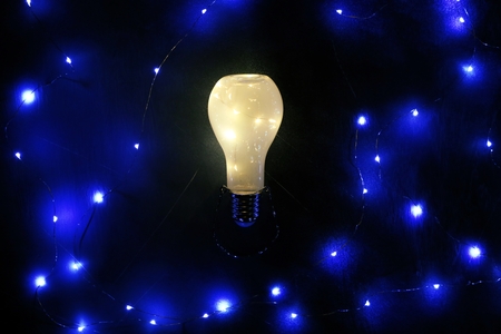 Glowing lightbulb on black backgroundの写真素材