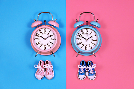 Two alarm clocks on blue pink background, twins conceptの写真素材