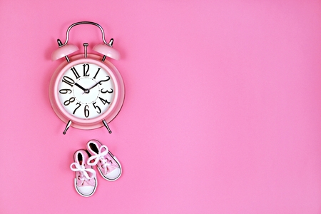 Alarm clock on pink background, its a girl conceptの写真素材