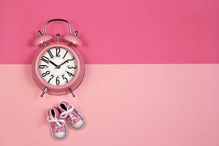 Alarm clock on pink background, its a girl conceptの写真素材