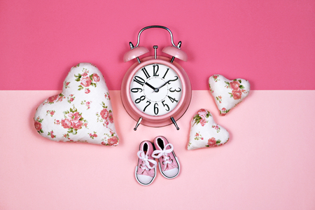 Alarm clock on pink background, its a girl conceptの写真素材