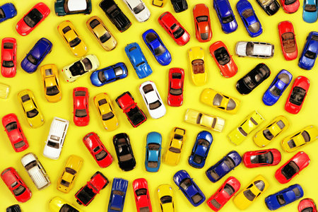 Many toy cars on yellow background, top view. Toy car set collection. Traffic jam conceptの写真素材