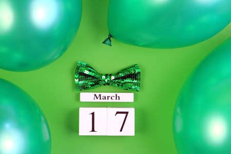 St Patricks Day greeting card. Block calendar, balloons and bow tie on green background.の写真素材