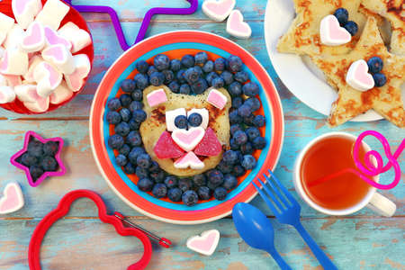Fun food for children. Lion or bear shaped pancakes on blue wooden table. Healthy eating. Creative idea for kids breakfast.の写真素材