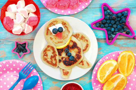 Fun food for kids. Bird shaped pancakes on blue wooden table. Healthy eating. Creative idea for children breakfastの写真素材