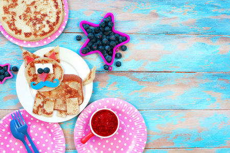 Fun food for kids. Cat shaped pancakes on blue wooden table, top view, copy space. Healthy eating for children. Creative idea for kids breakfastの写真素材