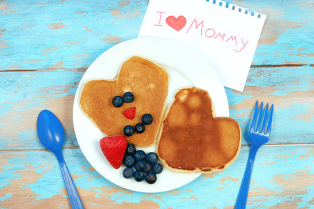 Heart shaped pancakes with blueberry and strawberry. Breakfast for mom on mothers day.の写真素材