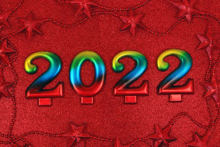 Happy New year and Christmas 2022 celebration concept. Festive multicolored number 2022 on red glitter background.の写真素材