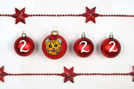 Christmas red ball decoration on white background painted with gouache. 2022 new year symbol tiger.