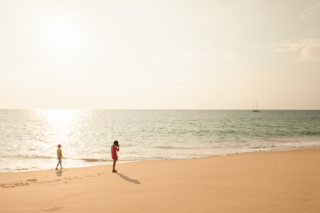 Happy girls photograph a beach at sunset. Tai Muang District, Phang Nga Province, Thailand.のeditorial素材