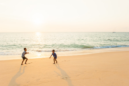 Phang Nga, Thailand â JANUARY 31, 2016: Happy children playing on the beach at sunset. Tai Muang District.のeditorial素材