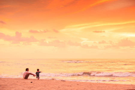 Phang Nga, Thailand â SEPTEMBER 18, 2010: Father and son seeing sunset and fantastic sky on Baan Nam Kem Beach, the beach after Thailand hardest hit by the Tsunami in 2004. Takua Pa District, Thailand.のeditorial素材