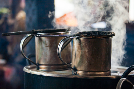 Old stainless steel pot and boiling hot water in Laos ancient coffee shop. Steam. Shallow depth of field. Luang Prabang Province, Laos.の写真素材