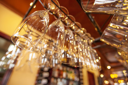 Wineâs glasses are perfectly clean hanging on the bar counter. Glistening warm lights. Wide angle. Sa Pa, Vietnam.の写真素材