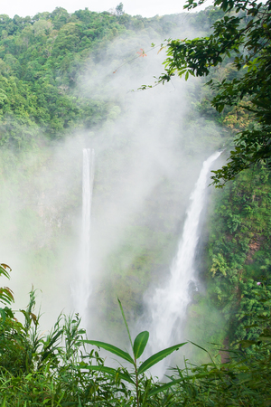 Great waterfall scenery in the mist. Tad Fane is a picturesque twin set of waterfall spilling 120 meters down into a deep gorge, rainforest spot is part of a big national park. Bolaven Plateau, Paksong, Laos. Rainy season.の写真素材