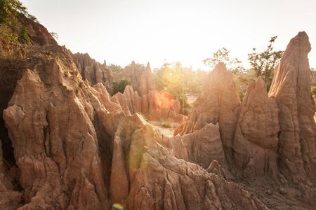 Golden sun shines down around the Sao Din Na Noi site displays picturesque scenery of eroded sandstone pillars. Ancient scenic landscape, similar Canyon. Fantastic columns and cliffs texture. Warm tone. Nan, Thailand.の写真素材