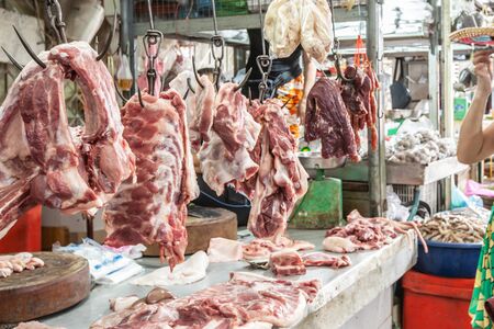 Meat hanging for sale in butcherâ€™s shop, variety of meat, pork, beef, chicken, ribs and...