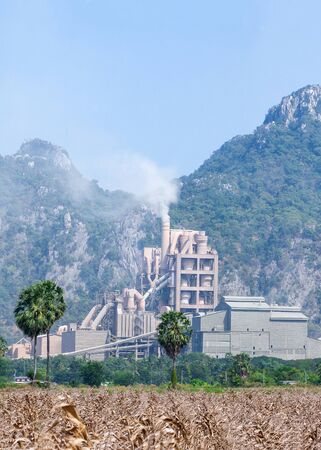 Panorama landscape of cement factory in thailand, corn fields foregrounds, limestone mountain range backgrounds.の写真素材