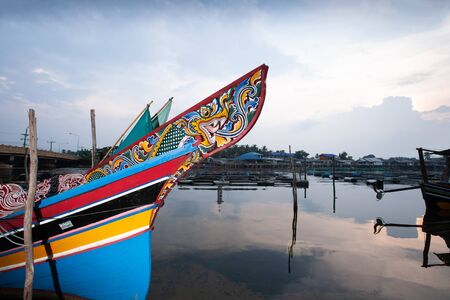 Beautiful a Kolae boat at local pier on the Bang Nara River at dusk. Kolae is a traditional Thai-Malayu fishing boat, vintage still life in Narathiwat, South Thailand. Public pier.の写真素材