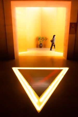 Chiang rai, Thailand - DECEMBER 1, 2010: Asian woman in casual suit walking against entrance of The Hall of Opium Museum. Golden Triangle.のeditorial素材
