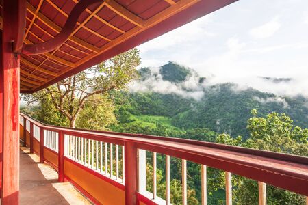 Tranquil mountains view from long iron balcony, picturesque of tropical mountain range in misty...