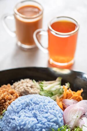 Purple rice salad or Khao Yam on white plate with milk tea, Southern Thai food. Selective focus.の写真素材