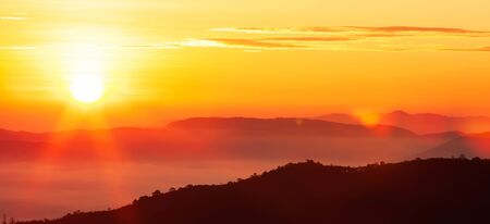 Glowing sunrise shines over mountain range, magical star shape ray from the sun with lens flare. Exploration, inspiration concept.の写真素材