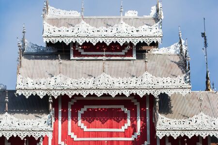 Elegant carved silver tin tiles, roof and window awnings of ancient buddhist temple. Wat Phrathat Doi Kong Mu, Mae Hong Son, Thailand. The temple is open to the public.の写真素材