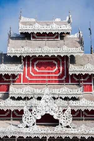 Elegant carved silver tin tiles, roof and window awnings of ancient buddhist temple. Wat Phrathat Doi Kong Mu, Mae Hong Son, Thailand. The temple is open to the public.の写真素材