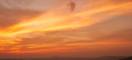 Dramatic sunrise sky over a mountain range, abstract ripple clouds on the wonderful sky. Positive emotions concept.の写真素材