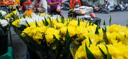 Fresh carnation flowers display at a local florist shop on a sidewalk, beautiful yellow and white carnations display at a local market in Thailand.の写真素材