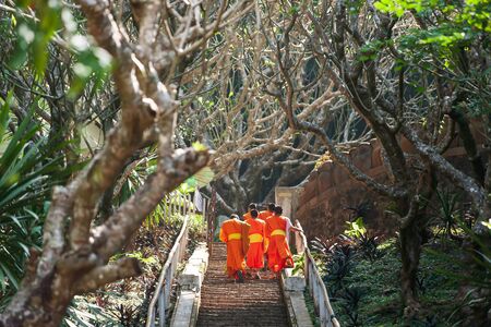 Rear view of Buddhist novice monks walking up stairway to Phou Si summit. Luang Prabang, Laos.  Low angle view.の写真素材