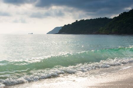 Tranquil tropical beach in summer, bright glittering on gently waves and surface of the sea. Koh Wua Ta Lap Island, Mu Koh Ang Thong National Park, Surat Thani, Thailand.の写真素材