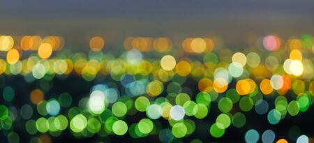 Defocus cityscape at twilight, bright and colourful blurred background with bokeh circle round lights, abstract bokeh for creative background. Night city life concept. Copy space.の写真素材