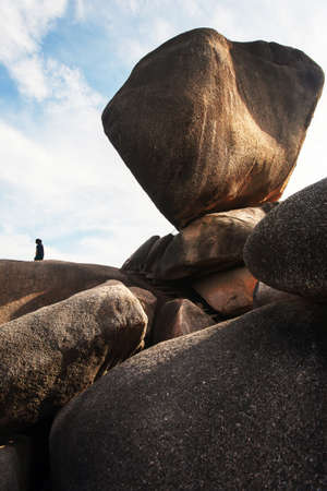 An unidentified female tourist stands on the precipice on summer morning, magical large rock on the precipice. Similan Islands, travel destinations in South Thailand.の写真素材