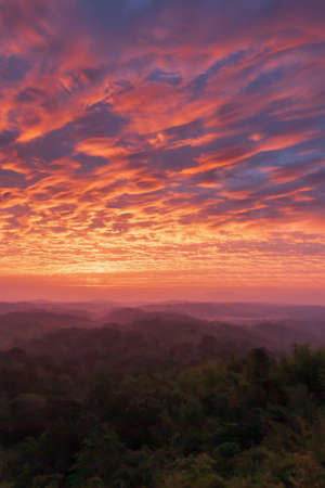Dramatic clouds on the sunrise sky over mountains range. Magical ripples clouds on the morning sky. North Thailand. Holiday, vacations, tourism concepts. Focus on clouds.の写真素材