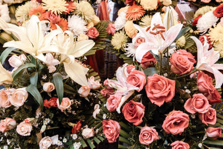 Colourful flowers display at a florist shop in a street market. Close-up lily, roses, carnations and...