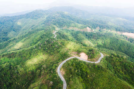 Aerial view of curve mountains road near Thailand-Myanmar border. Mountains road surrounded by green forest. Development, transportation concepts.の写真素材