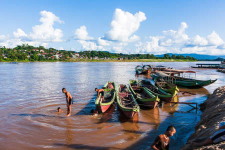 Chiang Rai, Thailand - OCTOBER 31, 2011: A group of children diving from the wooden boats into the Mekong River on a hot summer day. Chiang Khong.のeditorial素材