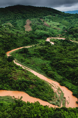 Aerial view of an overflowing creek with landslide on rainy season. Rural scene near Thailand-Myanmar border. Environment, climate change, weather concepts.の写真素材