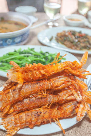 Cambodian cuisine sets, fried mantis shrimp, prawn soup and other seafood Khmer style with beverages. Sihanoukville, Cambodia. Close-up. Focus on fried mantis shrimp.の写真素材