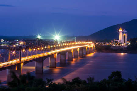 Picturesque Pakse Bridge over the Mekong River at dusk, illuminated lights reflection on the river. Champasak, Laos. Focus on the bridge.の写真素材