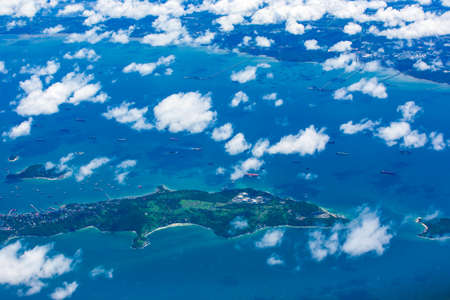 Aerial view of an island, port, cargo ships, container ships and an industrial zone. Gulf of Thailand. Transportation, industry, concepts. Selective focus.の写真素材