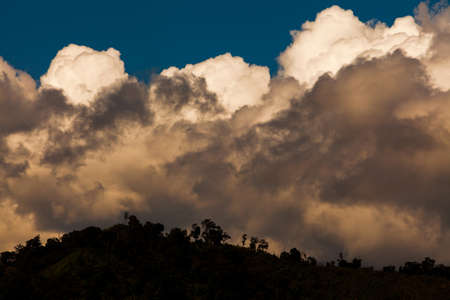 Dramatic rainstorms or thunderclouds over a tropical rainforest. Environment, climate change concepts. Focus on the clouds.の写真素材