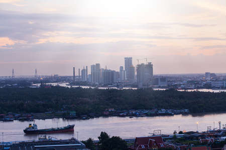 Aerial view of the Chao Phraya River and Bangkok Port, cargo ships, container ships, vessels, and local boats on the river at dusk. Bangkok, Thailand. International port, transportation.の写真素材