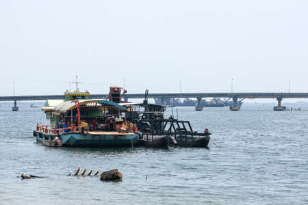 A group of pontoons floats machine moored on the Prek Khao Pao River near Koh Kong Bridge, mining tin from the sea in Cambodia.の写真素材