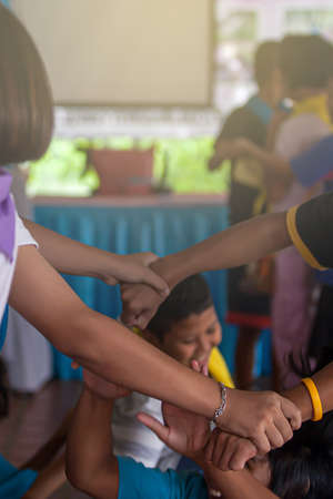 Close-up of diverse children's hands holding together during school field trips. Unity, teamwork, relationship concepts. Motion blur.の写真素材